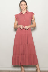 woman wearing a dusty rose tiered maxi dress with a collared neckline and ruffle sleeve details