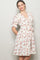 woman wearing a white floral wrap dress with short ruffled sleeves and a tied waist