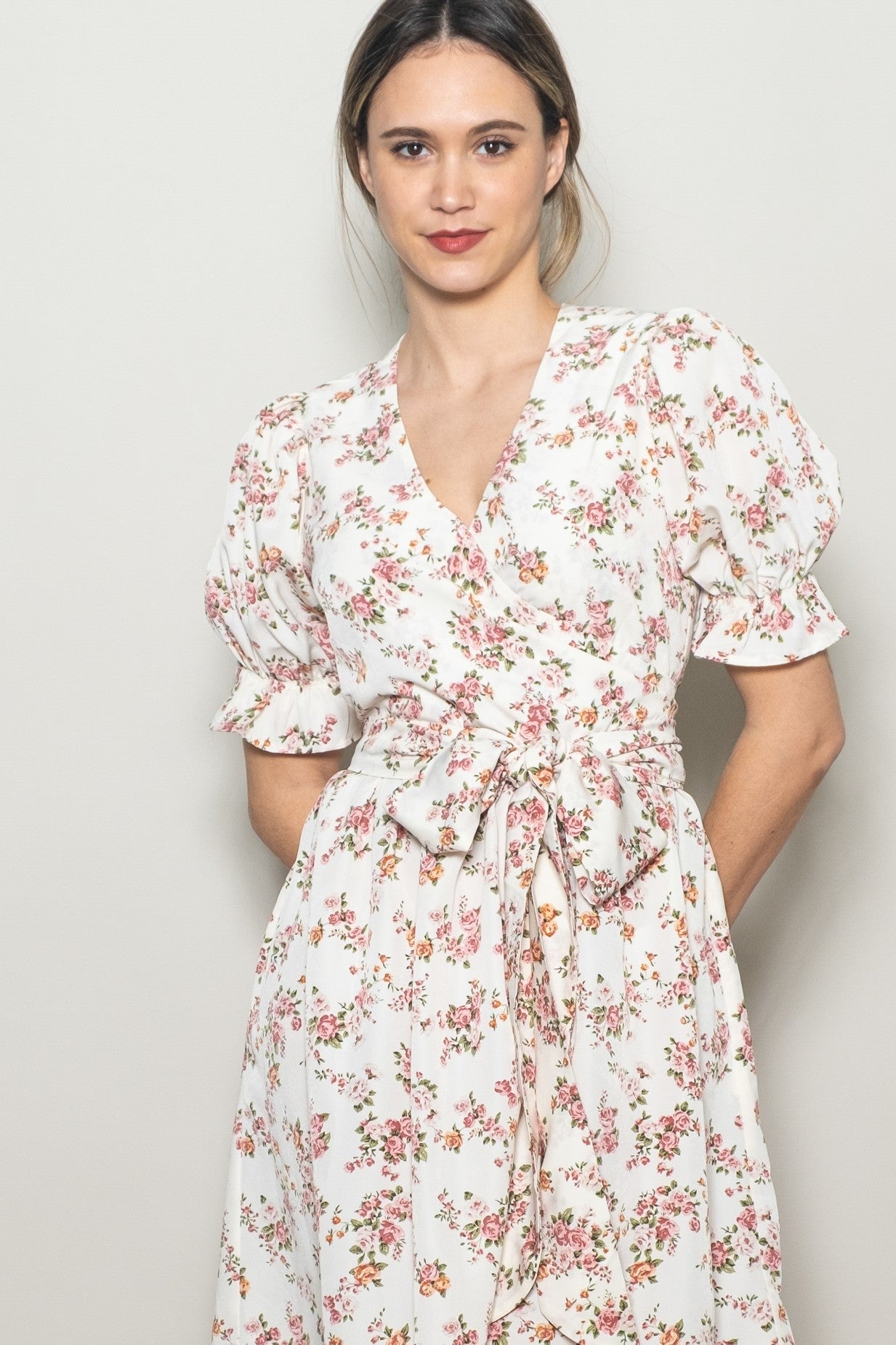 woman wearing a floral print wrap dress with puff sleeves and a v-neckline