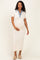 woman wearing a cream maternity dress with a denim collar, cradling her baby bump