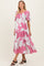 woman wearing a pink floral maternity dress with puff sleeves and a fitted bodice, showcasing her baby bump