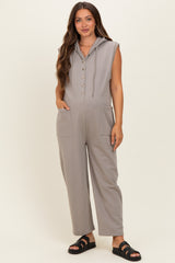 woman wearing a gray sleeveless maternity jumpsuit with hood and pockets, styled with sandals