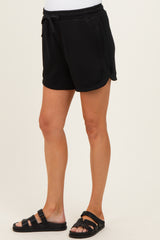 woman wearing black maternity shorts with a drawstring waist and side pockets