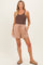 woman wearing a brown tank top and beige maternity shorts with a drawstring and pockets