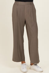 woman wearing taupe wide-leg trousers with a high waist and side pockets, paired with white sneakers