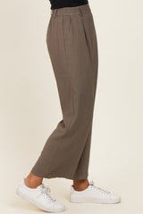 woman wearing taupe wide-leg trousers with an elastic waistband and white sneakers