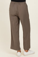 woman wearing olive green wide-leg trousers with an elastic waistband and side pockets, viewed from the back