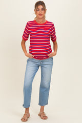 woman wearing a red and blue striped maternity top with rolled sleeves and light wash jeans, showing a baby bump