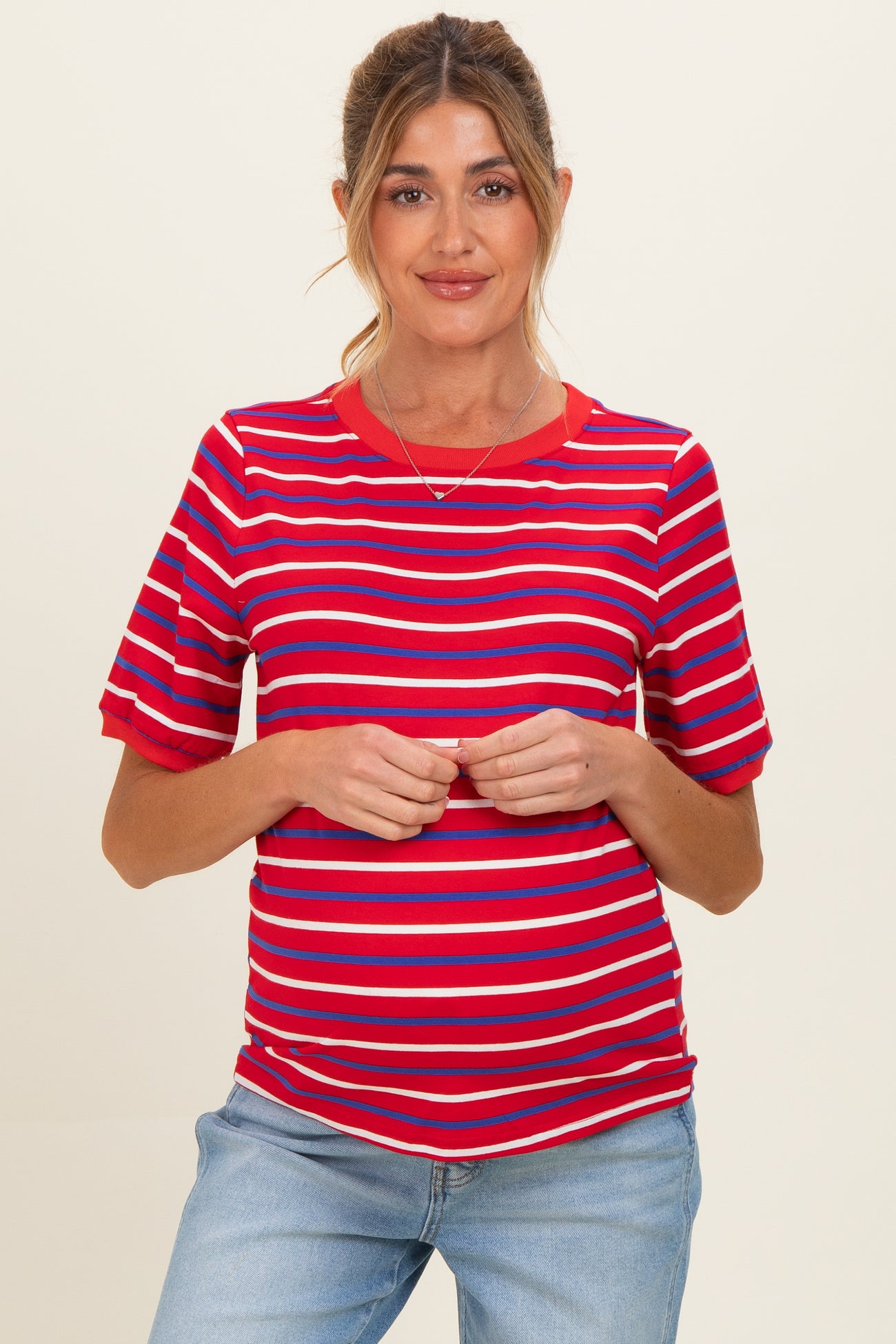 woman wearing a red and blue striped maternity top with short sleeves and a visible baby bump