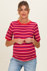 woman wearing a red and blue striped maternity top with short sleeves and a visible baby bump