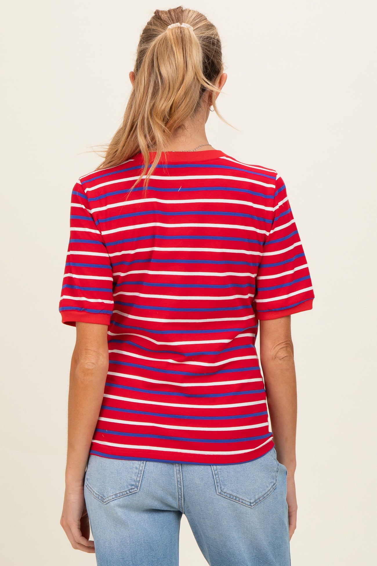 woman wearing a red and blue striped maternity t-shirt, shown from the back