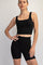 woman wearing a black sports crop top and high-waisted black cycling shorts