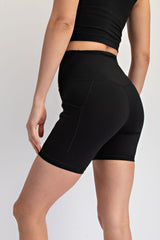 woman wearing black high-waisted biker shorts, showing a fitted style and rear view