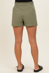 woman wearing olive green maternity shorts with an elastic waistband, shown from the back