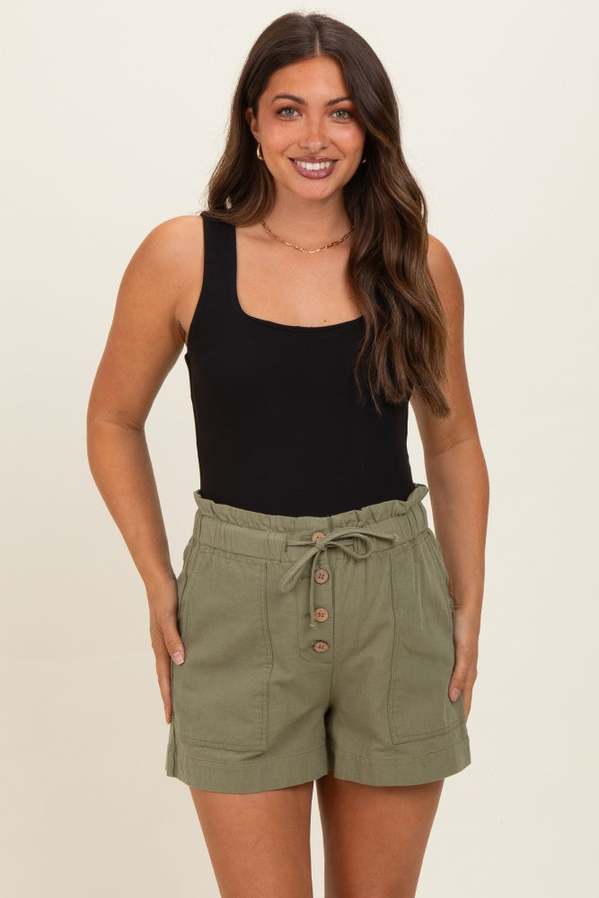 woman wearing a black maternity tank top and olive green maternity shorts with buttons and an elastic waist