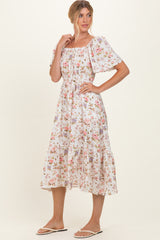 woman wearing a white floral midi dress with puff sleeves and a gathered waist, styled for a casual look