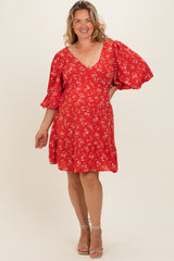 woman wearing a red floral maternity dress with puff sleeves and a v-neck, showcasing her baby bump
