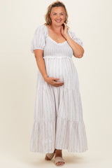 woman wearing a white puff sleeve maternity maxi dress with floral print and holding her baby bump