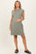 woman wearing a green short sleeve maternity dress and holding her baby bump
