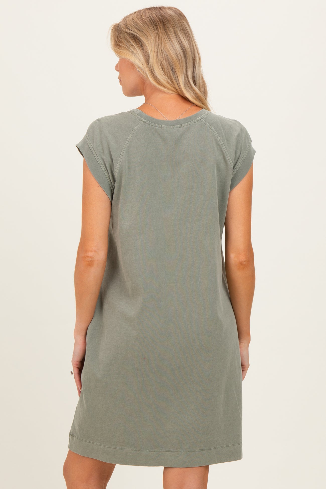 woman wearing a green short sleeve maternity dress from the back