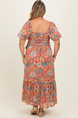 woman wearing a floral printed maternity plus maxi dress with a smocked bodice and flutter sleeves, viewed from the back
