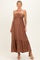 woman wearing a brown maternity maxi dress with a smocked bodice and tiered skirt, showcasing her baby bump