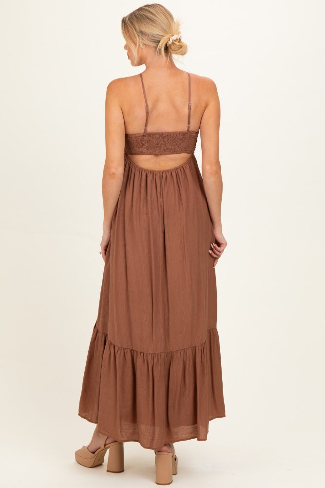woman wearing a brown maternity maxi dress with a smocked back and tiered hem