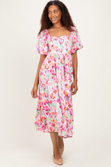 woman wearing a pink floral midi dress with puff sleeves and a square neckline