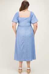 woman wearing a blue floral print maternity dress with short puff sleeves and an elasticated waist, showing her baby bump