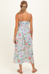 woman wearing a floral smocked back maternity dress with adjustable straps and a flowy skirt