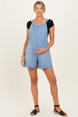 woman wearing a light blue denim maternity overall shorts and holding her baby bump