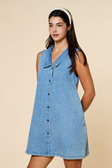 woman wearing a light blue denim sleeveless dress with a collar and button-down front