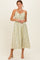 woman wearing a light yellow floral midi dress with adjustable straps and a gathered bust design