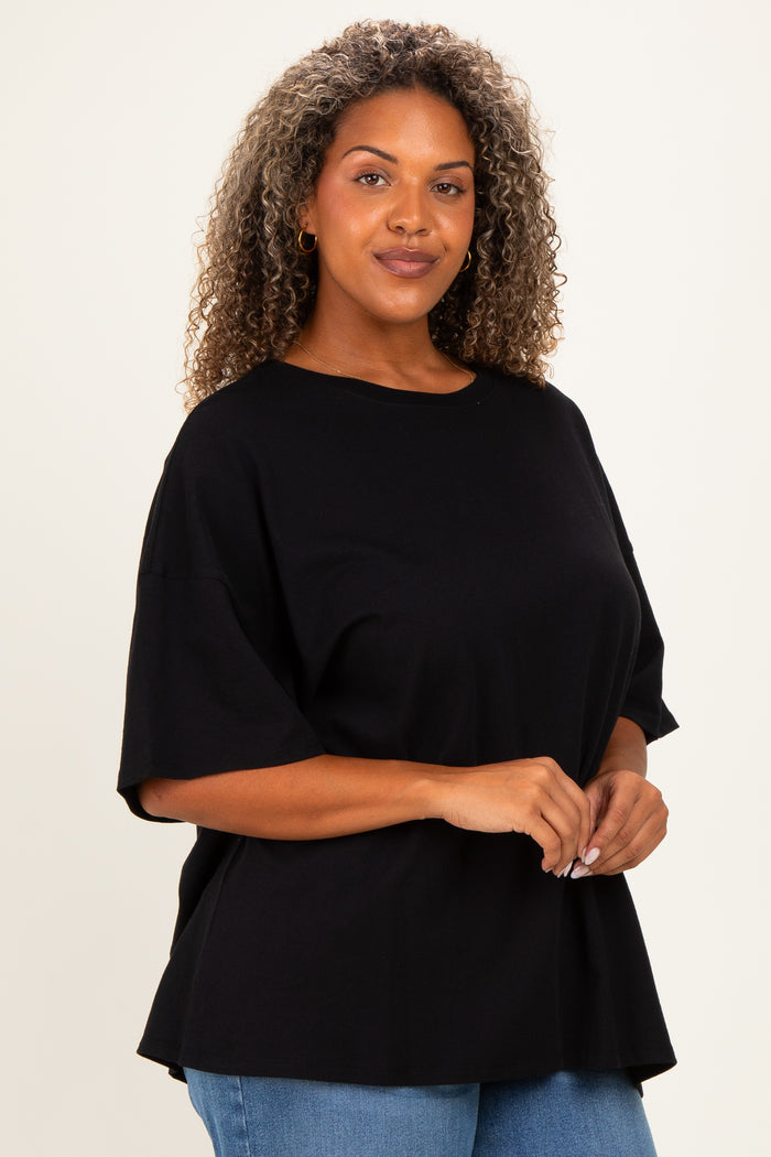 woman wearing a black oversized t-shirt and blue jeans with curly hair and a casual pose