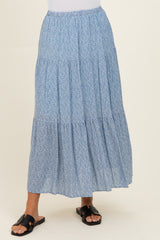 woman wearing a blue floral tiered maxi skirt with an elastic waistband and black slide sandals