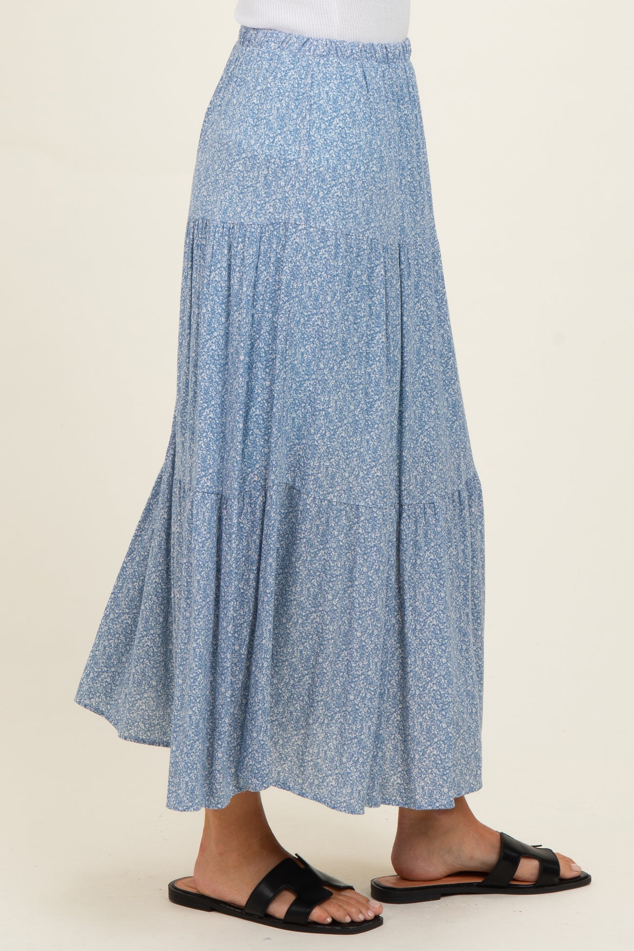 woman wearing a light blue floral maxi skirt with tiered design and a relaxed fit