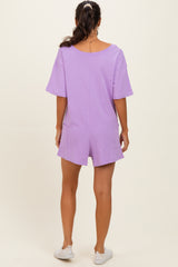 woman wearing a lavender short sleeve romper with pockets, viewed from the back