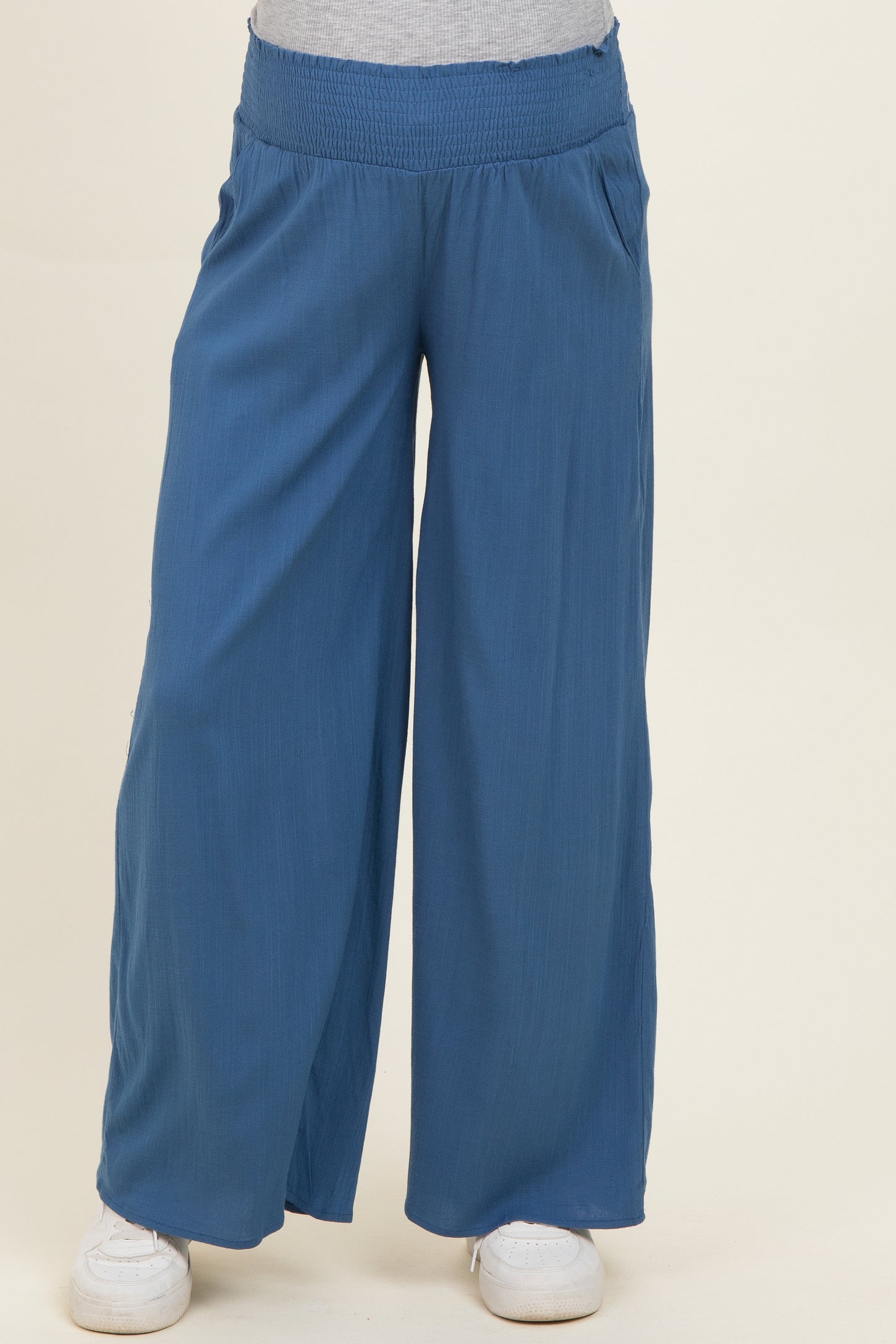 maternity wear blue wide-leg pants with a smocked waistband and side pockets, model wearing them with a gray top