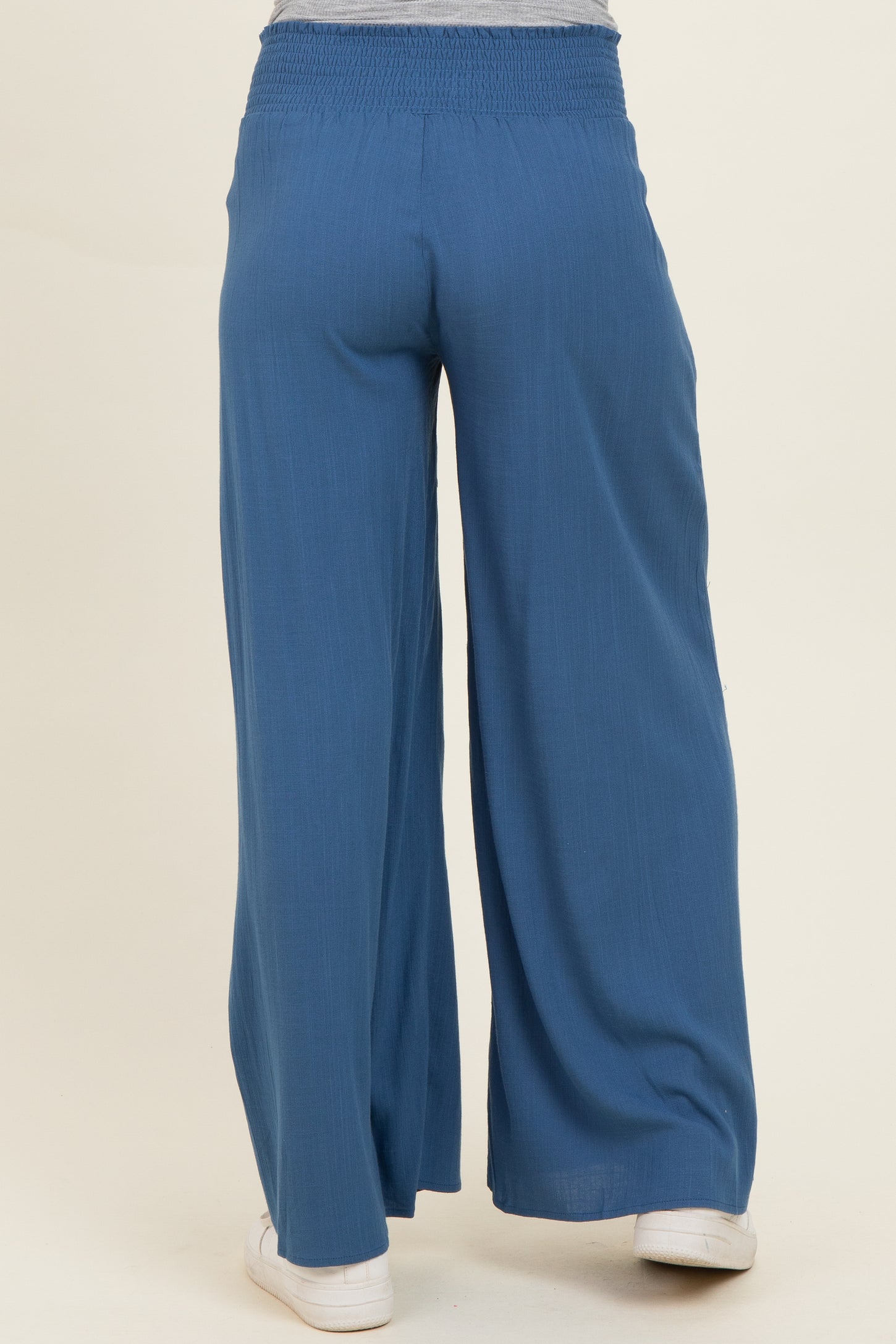 woman wearing blue wide-leg maternity pants with a smocked waist from the back