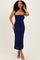 woman wearing a navy blue strapless midi dress with floral cutout details at the hem