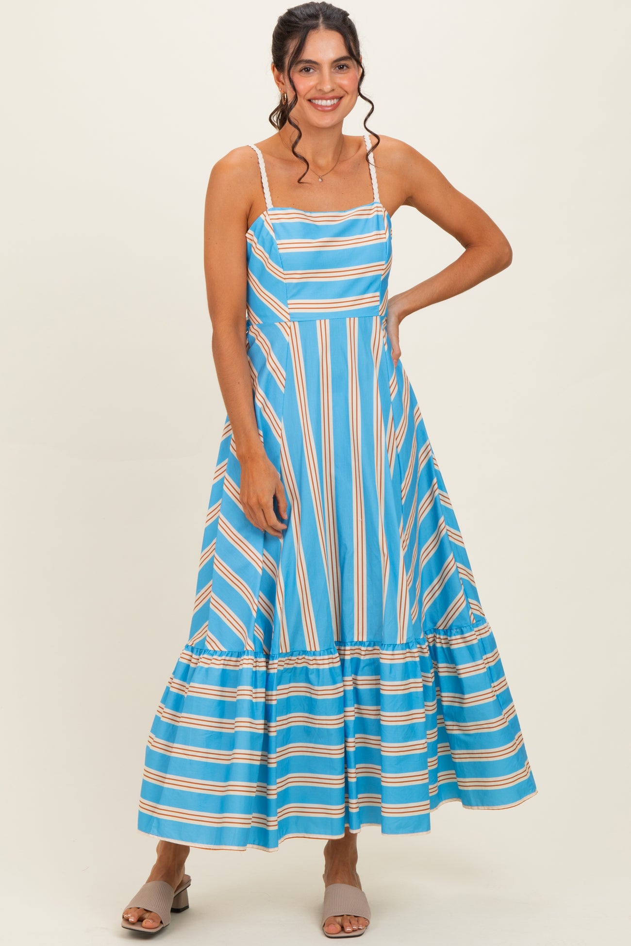 woman wearing a blue stripe maxi dress with a ruffled hem and thin shoulder straps
