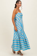 woman wearing a blue and white striped maxi dress with spaghetti straps and a tiered hem