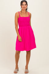woman wearing a bright pink sundress with a smocked bodice and adjustable straps