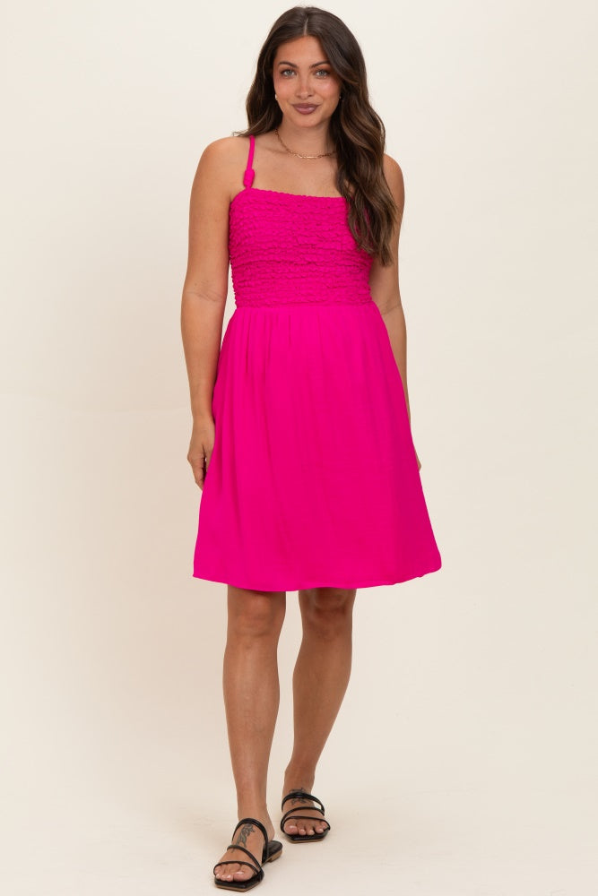 woman wearing a fuchsia maternity dress with a smocked bodice and adjustable straps