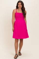 woman wearing a fuchsia maternity dress with a smocked bodice and adjustable straps