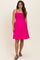 woman wearing a fuchsia maternity dress with a smocked bodice and adjustable straps