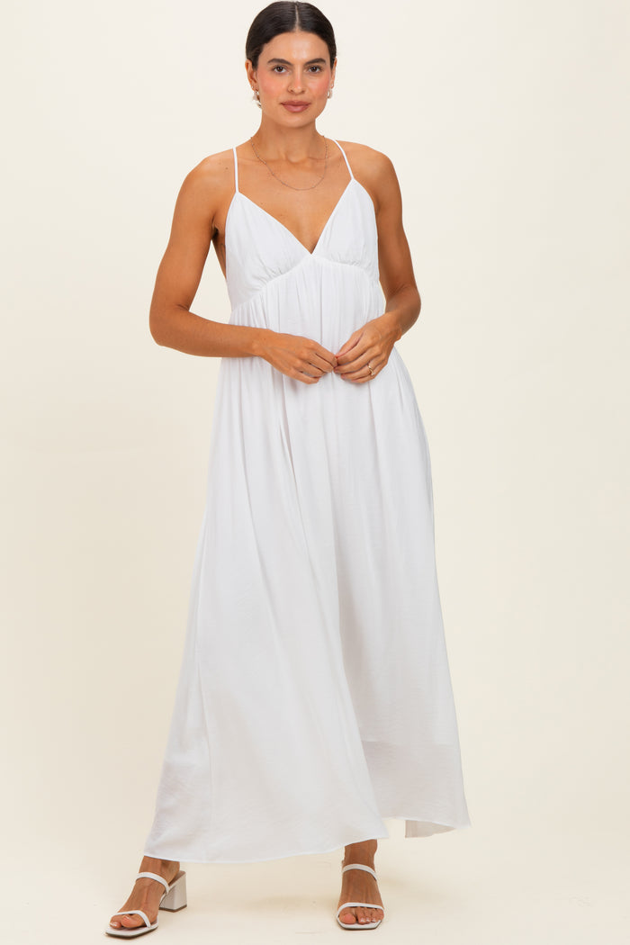 woman wearing a white maxi dress with thin straps and a flowing silhouette