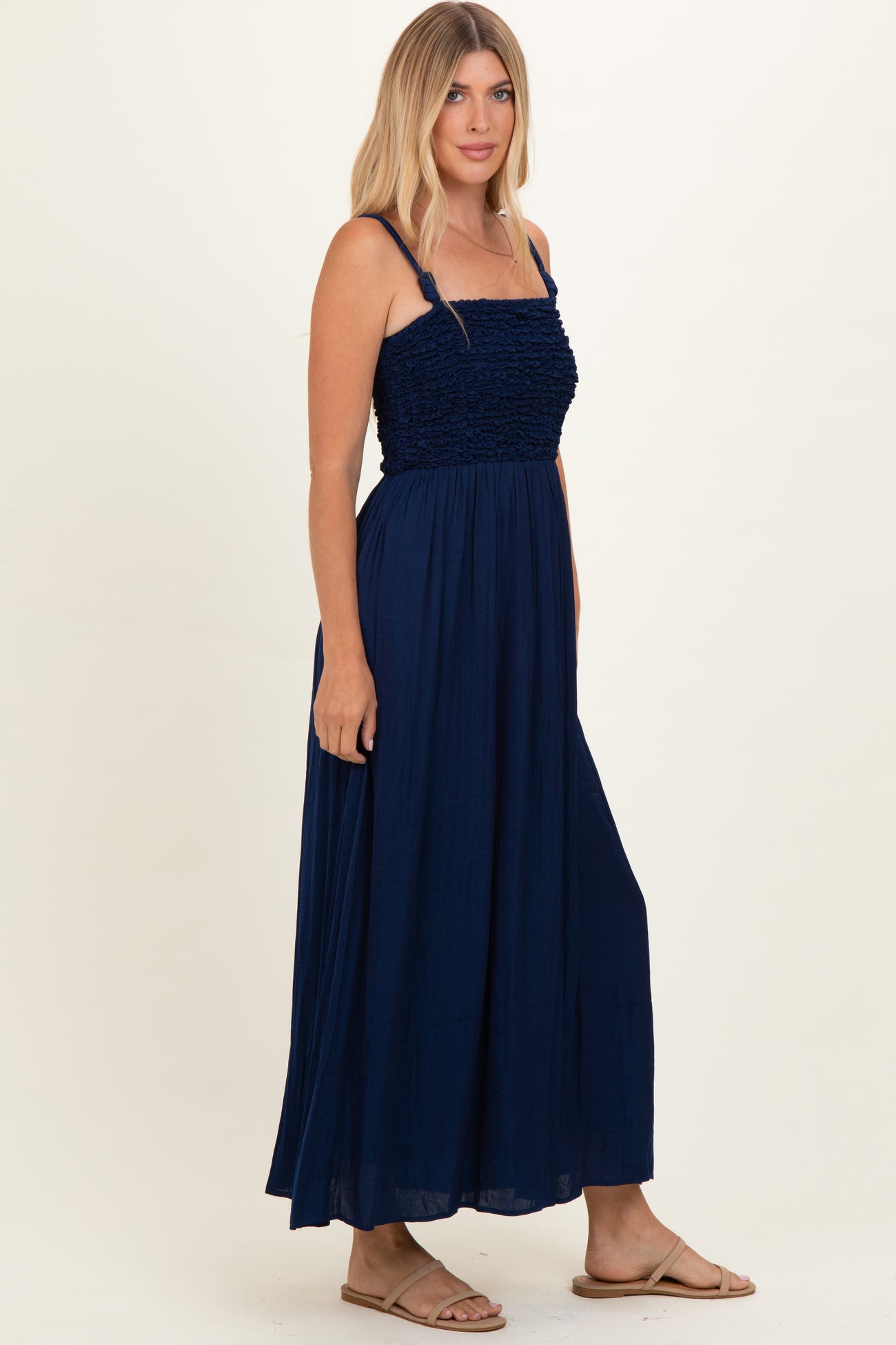 woman wearing a navy blue maxi dress with a smocked bodice and adjustable straps