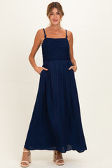 woman wearing a navy blue maxi maternity dress with smocked top and pockets