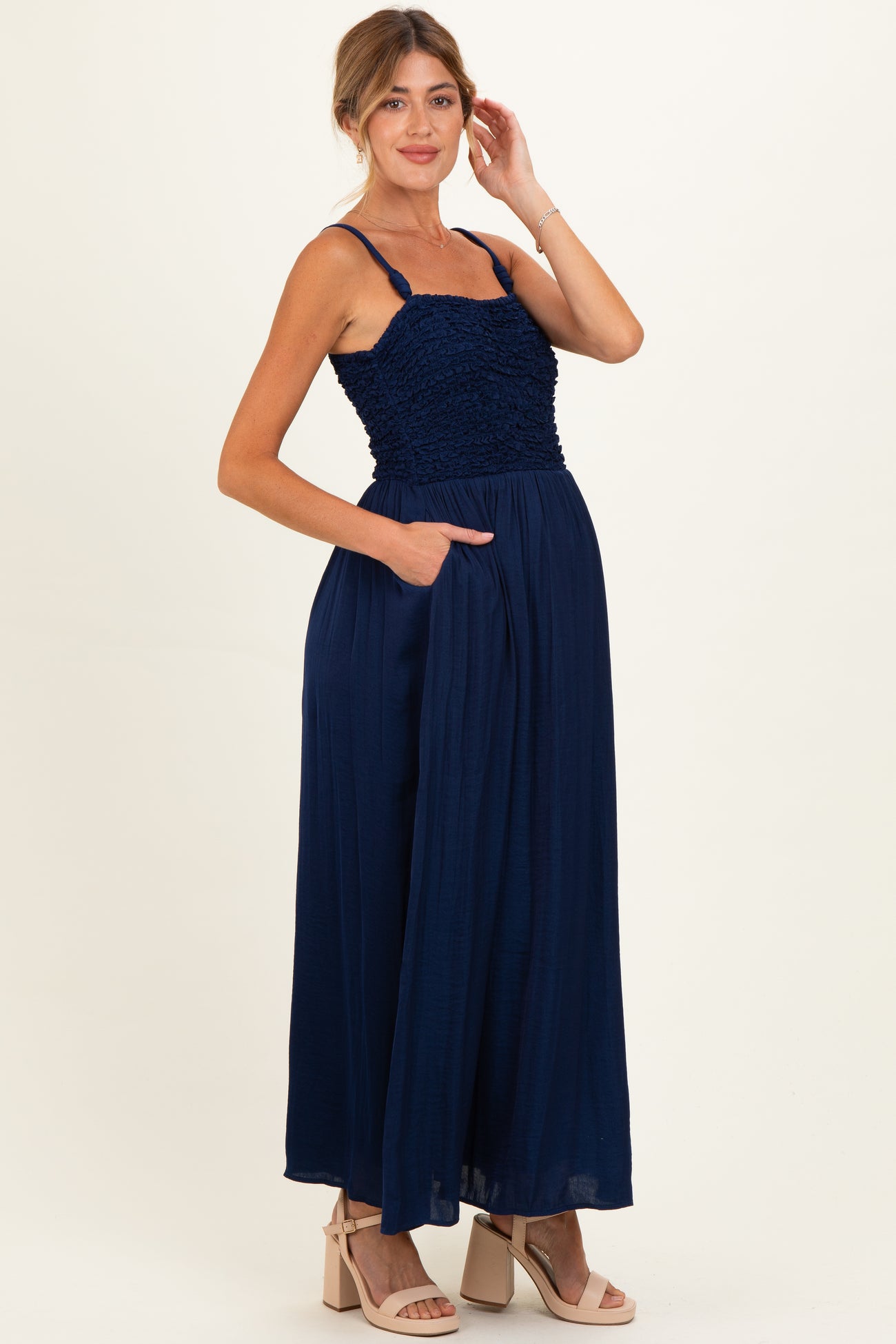 woman wearing a navy blue maternity maxi dress with a smocked bodice and pockets